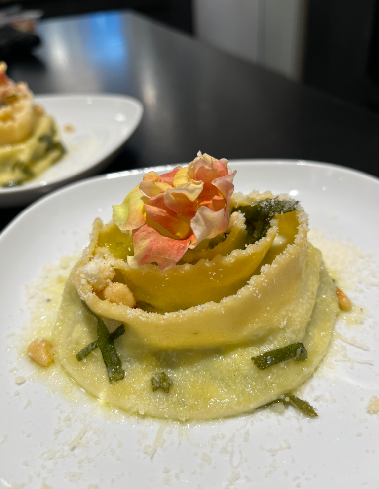 Pappardelle in Rosettenform Selbstgemachte Nudel in Rosettenform mit essbarer Blüte, Pinienkernen und Parmesankäse